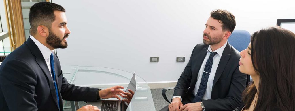 Abogado conversando con dos clientes en su Despacho de Abogados
